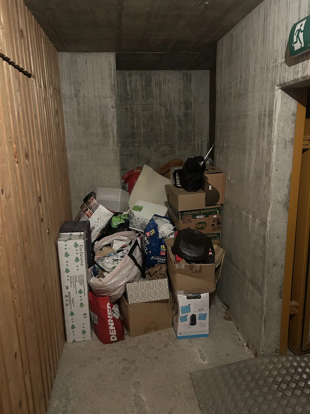 Cave d'immeuble encombrée de cartons et sacs avant débarras, région de Fribourg