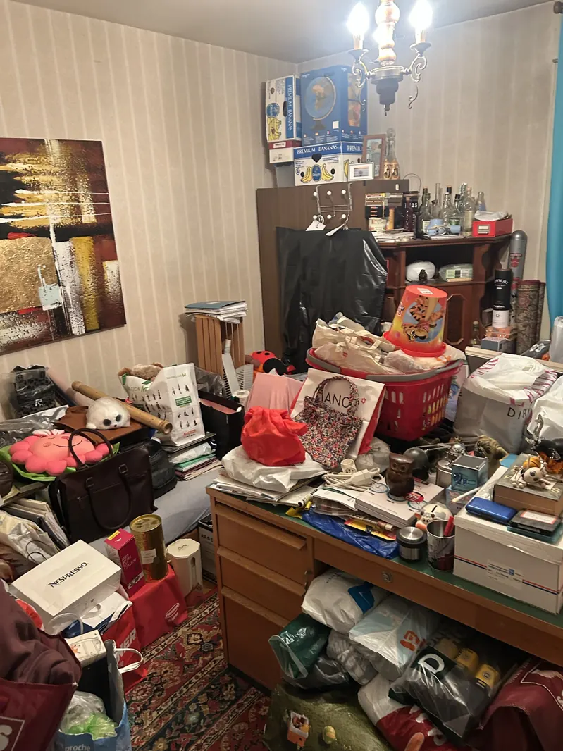 Bureau rempli d'objets personnels, cartons et sacs avant un débarras de succession dans le canton de Fribourg